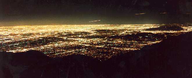 Wide panoramic view of the Los Angeles city grid illuminated with glowing amber and golden streetlights.