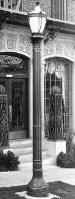 B&W night shot of a single lantern post casting light on a historic storefront.